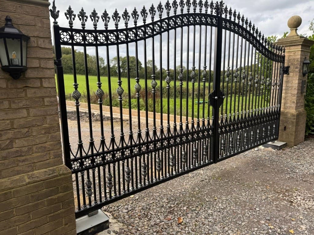 Classic ornate black wrought-iron double driveway gate with arched top